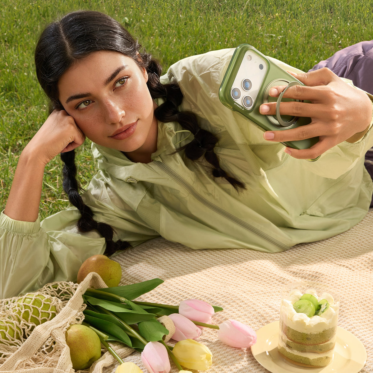 Green TORRAS Ostand O3 Air case for iPhone 17 Pro with integrated ring stand, held by woman.